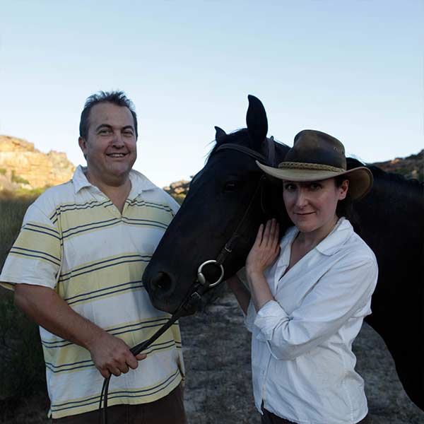 Henrietta Lovell & Dr. Frikkie Strauss standing with a horse in the Cederberg Mountains.