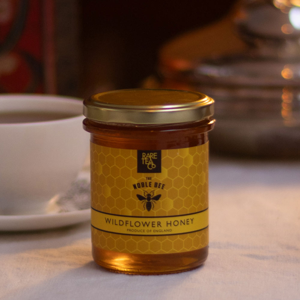 Jar of Rare Tea Company wildflower honey with a tea cup in the background.